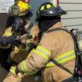 Two firefighters practice their entry skills on the forcible entry prop.